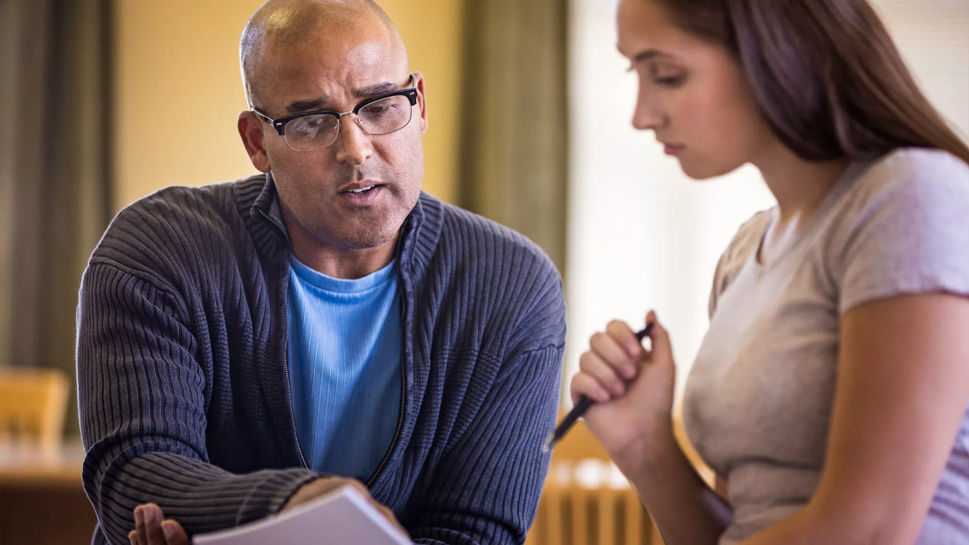 Two educators look over bargaining proposals together.