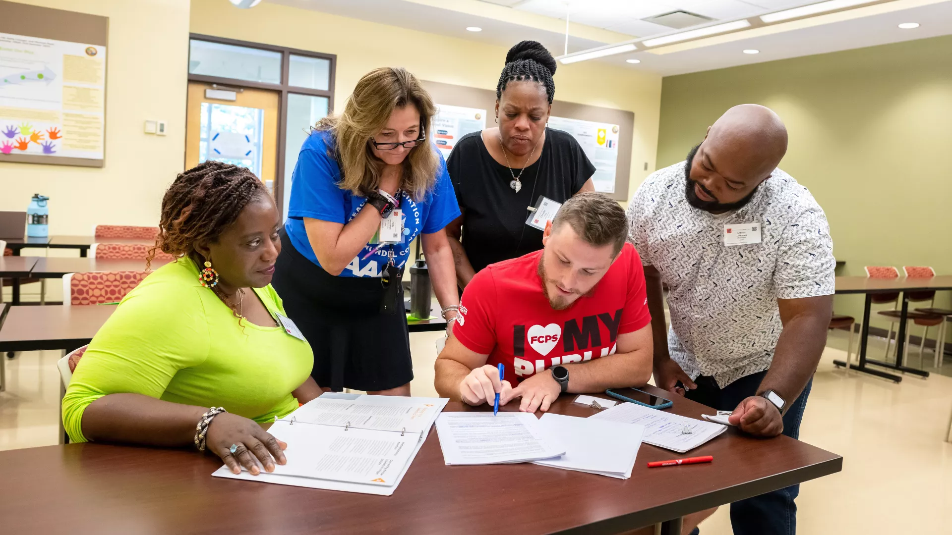 Educators review a negotiated agreement while making notes.