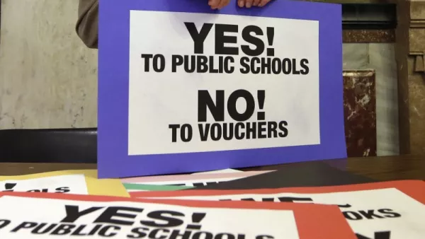 A pile of signs that say "Yes! To Public Schools. No! To Vouchers!"