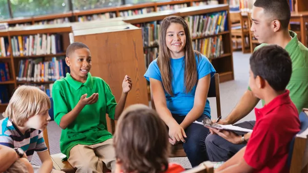 diverse students talking in a circle in school library