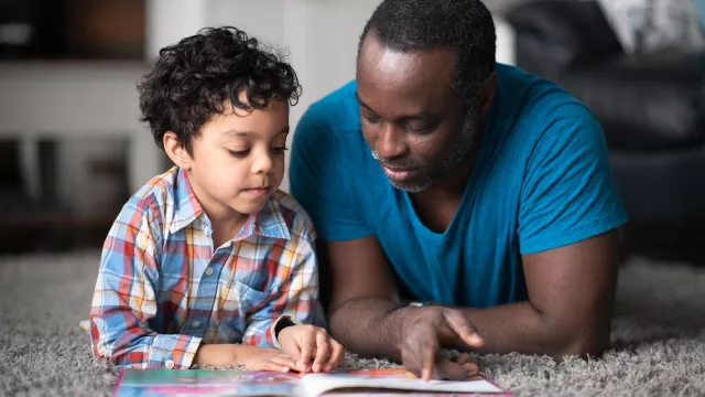 A father and son read together